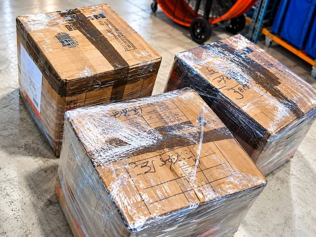 Boxes of supply kits wrapped in plastic film at the shipping office